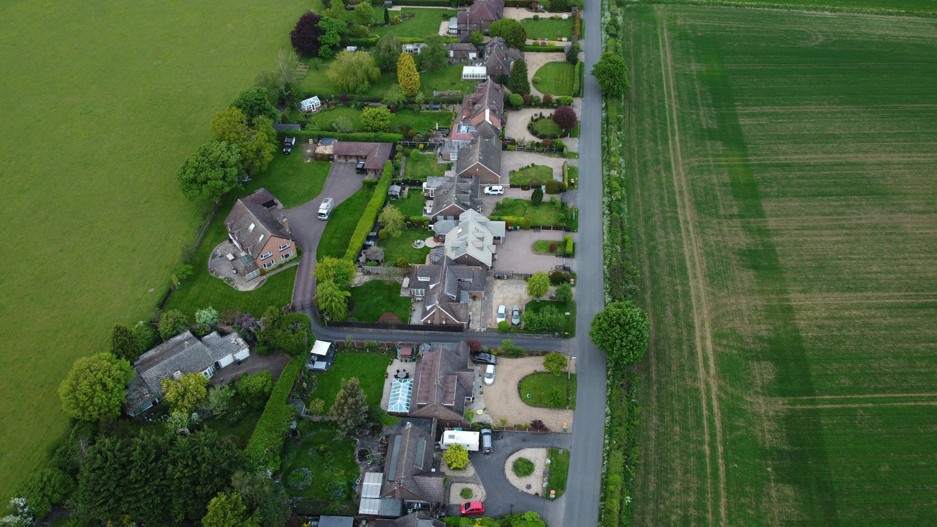 Aerial view of traditional British residential houses and green gardens in Surrey